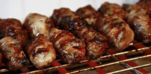 Gnummareddi, kleine Röllchen aus Lammorganen, über Glut gegrillt