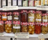 Regal mit handwerklichen Konserven aus Apulien: Gemüse in Öl, Oliven und natives Olivenöl extra