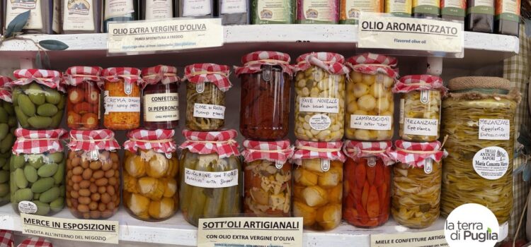 Regal mit handwerklichen Konserven aus Apulien: Gemüse in Öl, Oliven und natives Olivenöl extra