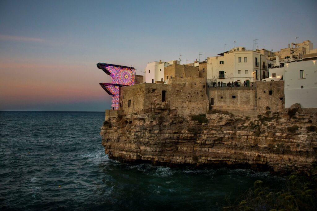 Die Plattformen des Red Bull Cliff Diving mit salentinischen Luminarie auf der Klippe von Polignano a Mare bei Sonnenuntergang