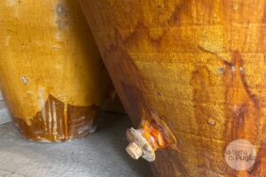 Zwei große, braungelb glasierte Terrakottagefäße aus Apulien, eines mit einem Korkstopfen im Ablaufloch